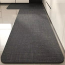 Black, long kitchen mat made of waterproof PVC.