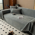Minimalist chenille sofa towel in Herribone style with fringed border.